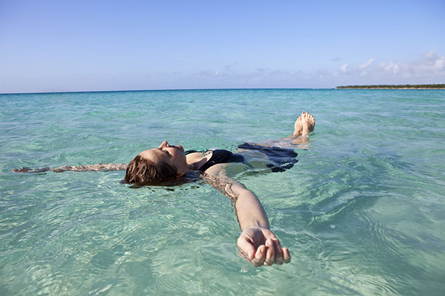 Image of women floating and relaxing in an open body of water.