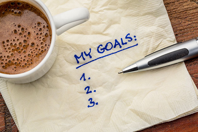 Image of "my goals" list on a napkin with cup of coffee.