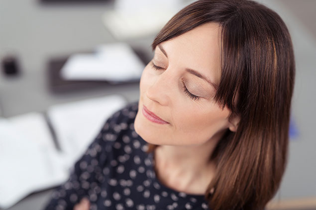 Image of women relaxing with eyes closed.