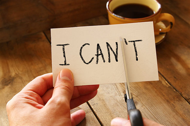 Image of hand holding card with the text "I can't", cutting the word so it written "I can".