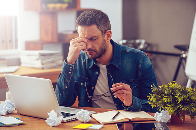 Image of man stressed with a headache.