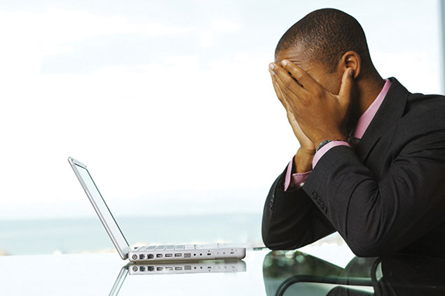 Image of stressed business man in front of laptop.