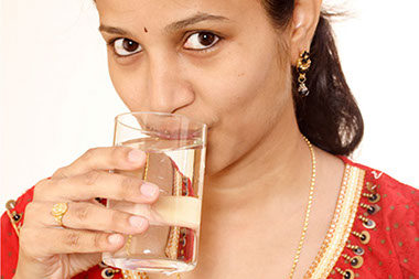 Image of women drinking a glass of water.