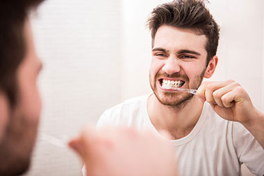 Image of man brushing teeth.