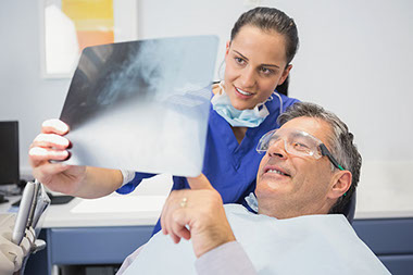 Image of man at the dentist office looking at xrays.