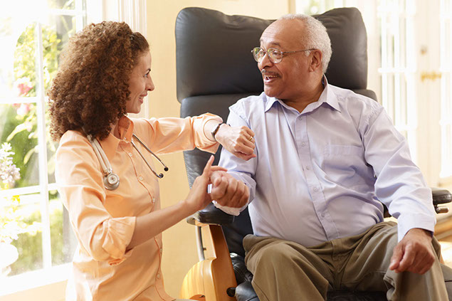Image of happy man getting pulse checked by nurse at senior living home.