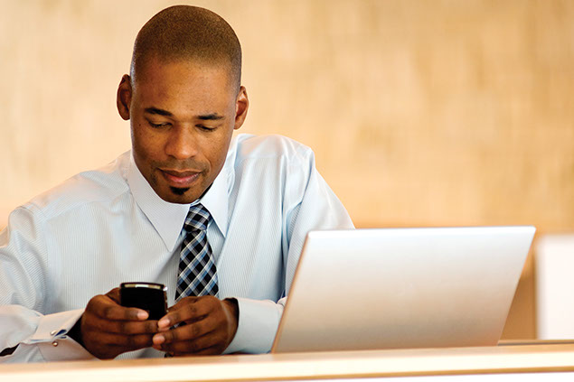 Image of business man with laptop and smart phone.