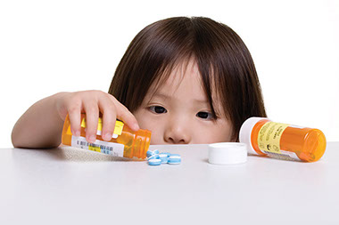 Image of child with access to an open prescription bottle.