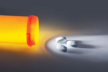 Image of open pill bottle with 3 pills next to the bottle.