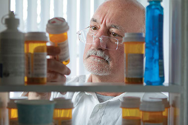 Image of man looking in his medicine cabinet.