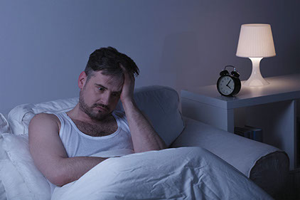 Image of man awake in bed.