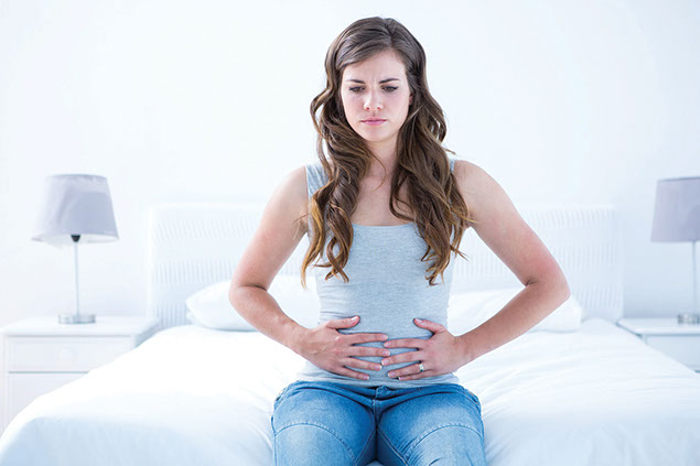 Image of a women holding stomach in pain.