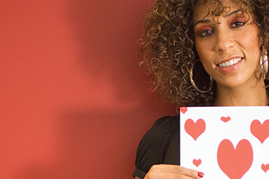 Image of women holding a paper with hearts on it.
