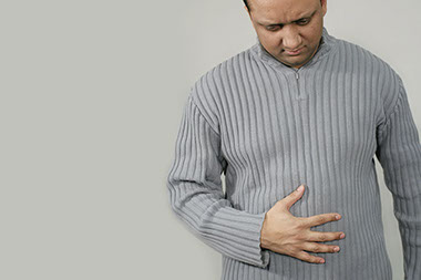 Image of man holding this stomach.