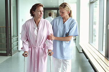 Image of nurse helping a women walk.