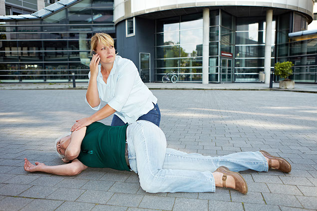 Image of women on phone beside someone who is unresponsive.