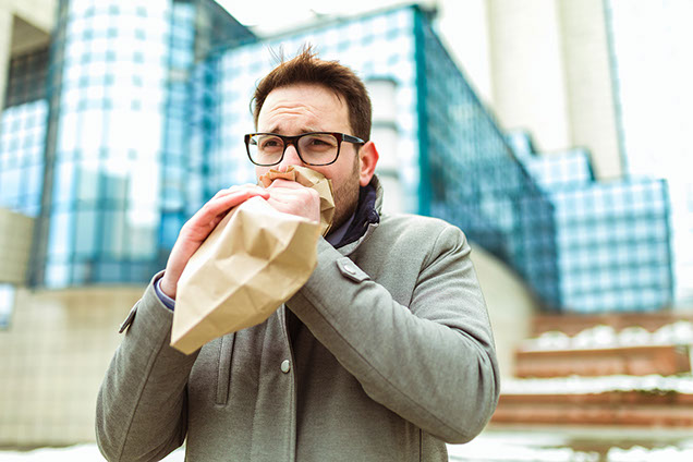 Man holding paper bag over mouth to help stop hyperventilation.