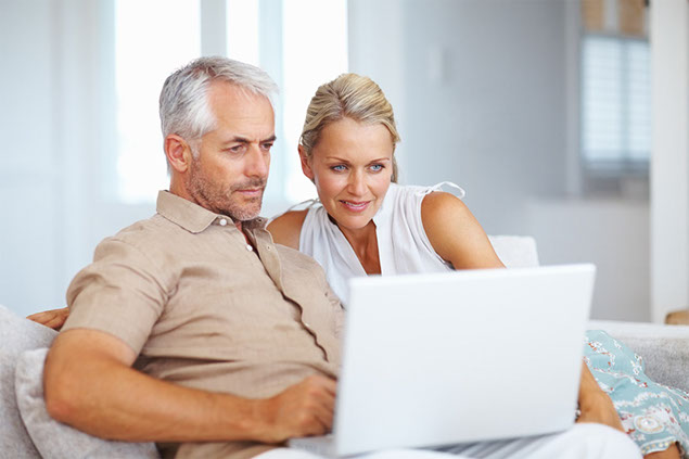 Image of couple looking at laptop screen.