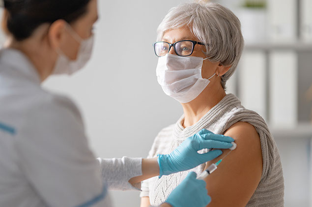 Older female receiving vaccine shot.