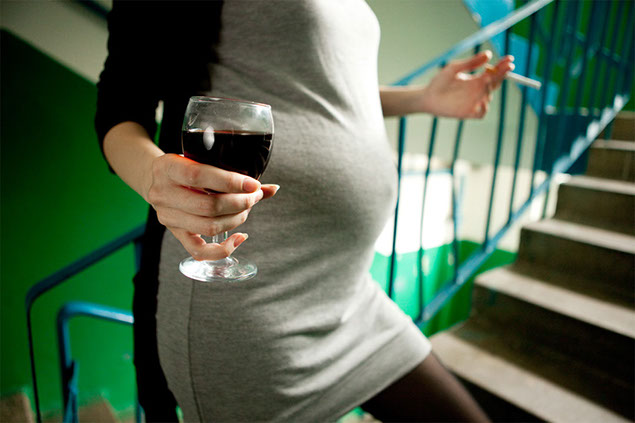 Image of pregnant women holding a glass of wine.