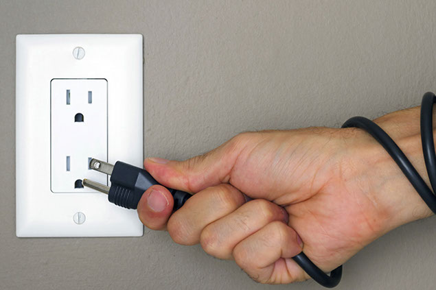 Image of person plugging in a cord.