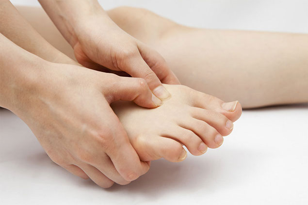 Image of hand placing pressure on foot.