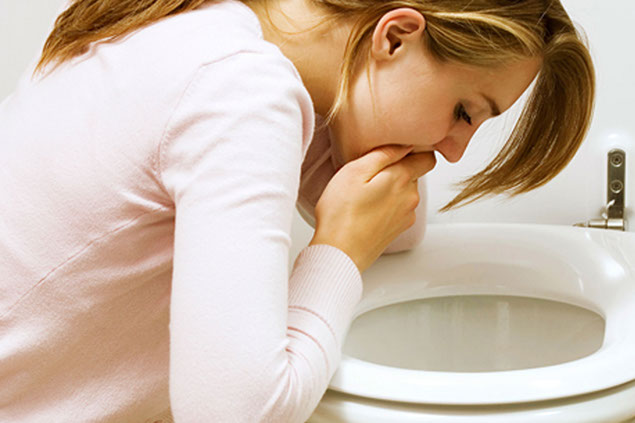 Image of women vomiting in toliet.
