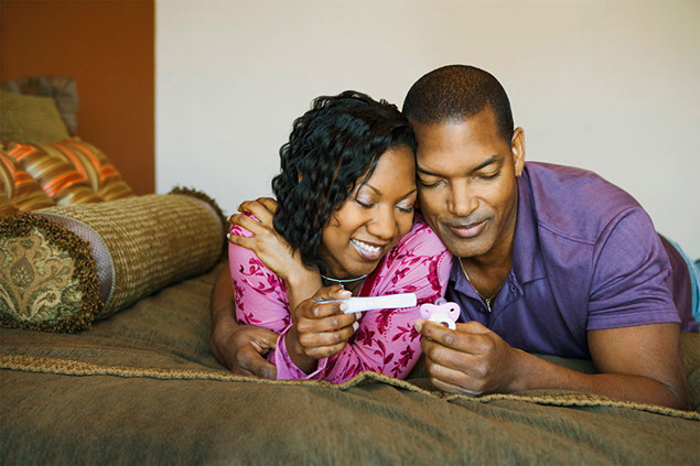 Image of happy couple looking at pregnancy test.