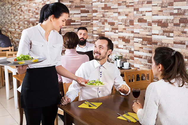 Waitress delivering food to table.