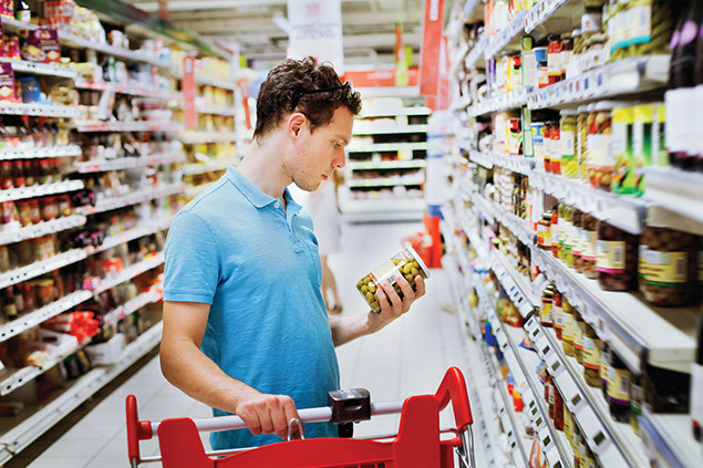 Man reading food label in the grocery store.