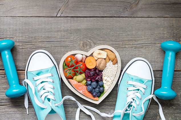 Healthy lifestyle concept with food in heart and sports fitness accessories.