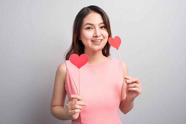 Woman holding red heart shape.