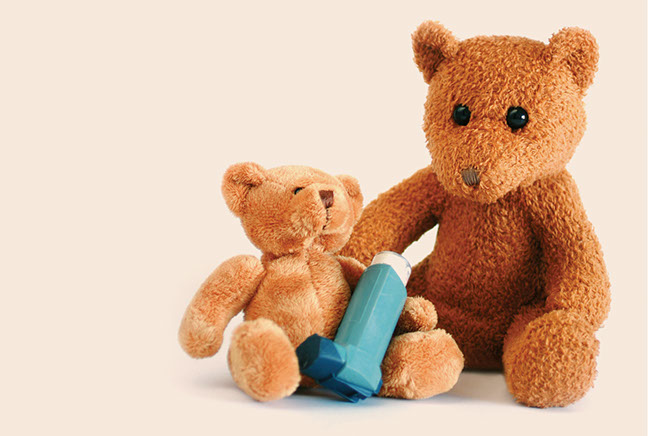 Image of 2 teddy bears next to an asthma inhaler.