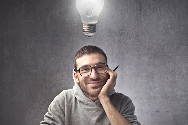 Image of smiling young man with a light blub above his head.