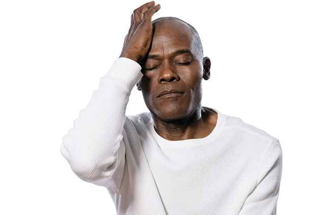 Image of man with hand on his head.