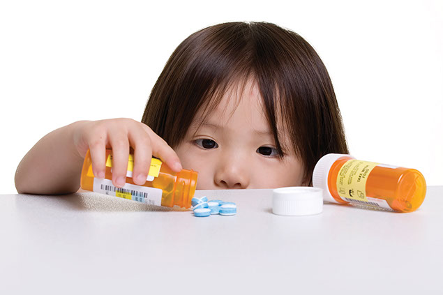 Image of child with access to an open prescription bottle.