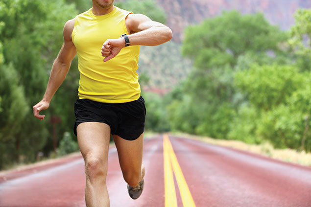 Image of man running while looking at his watch.