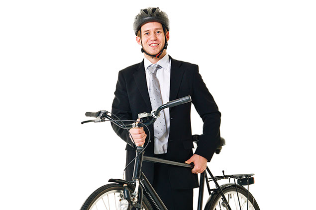 Image of young man in a business suit with a bike and helmet on.