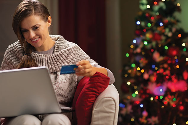 Image of female on laptop with credit card in hand.