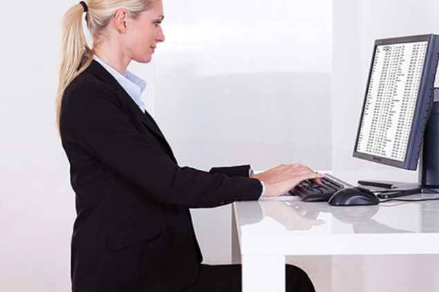 Image of business women sitting at desk with correct posture.