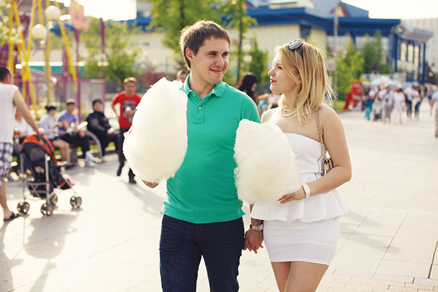 Image of couple walking at a state fair with cotton candy.