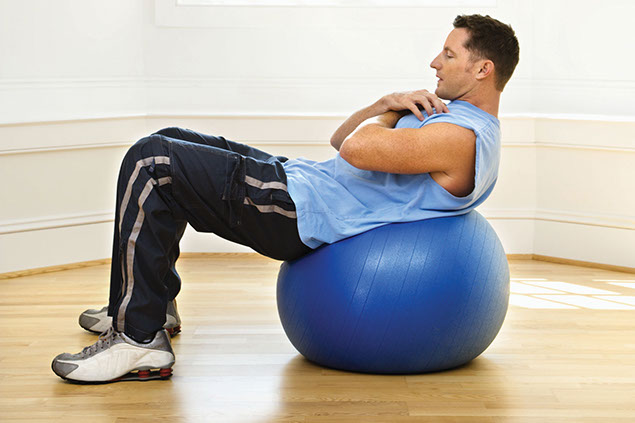 Image of man using a fitness ball to do ab exercises.