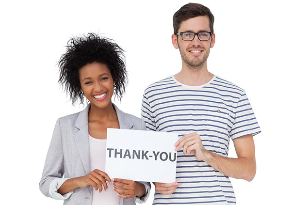 Image of 2 people holding up a thank you sign.