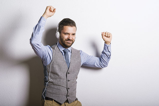 Image of middle-aged man with headphones on dancing.