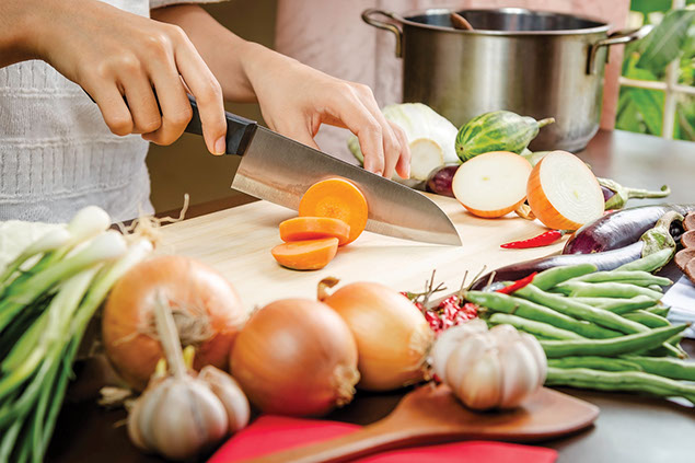 Image of a person cutting carrots.