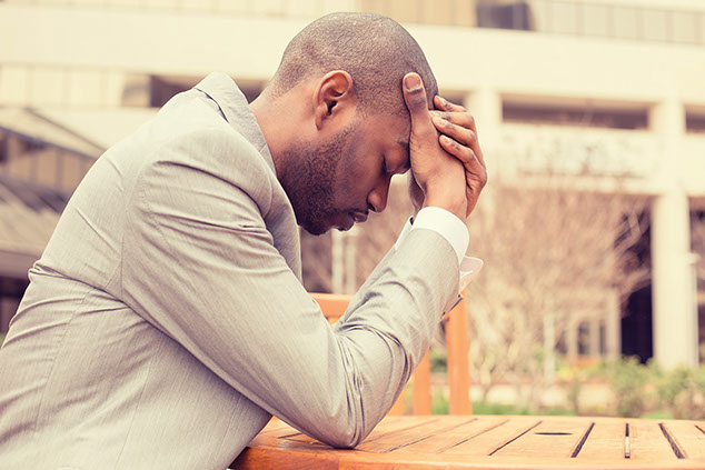 Image of man with hands on forehead.