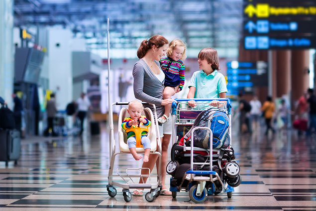 Image of mom with 3 children at the airport.