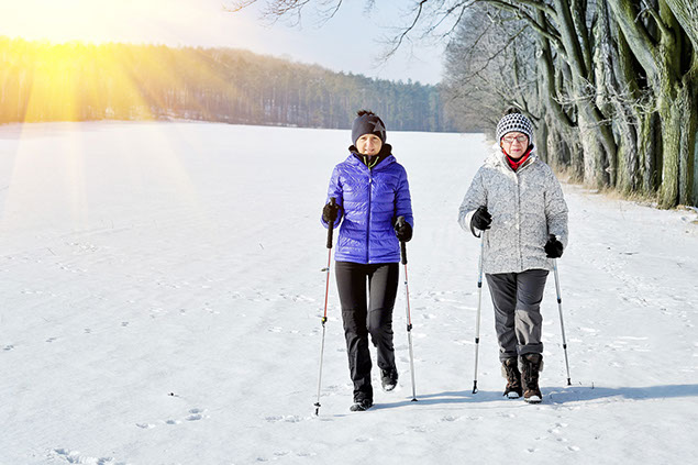 Image of two female friends walking outside in the winter.