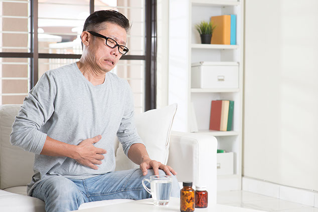 Image of man holding his stomach in pain.