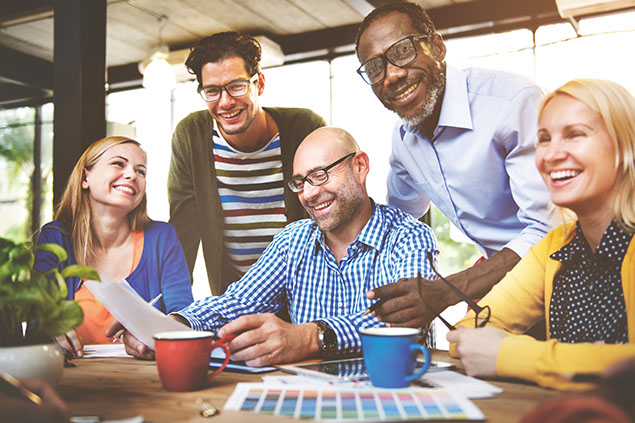 Image of a group of co-workers smiling and laughing.